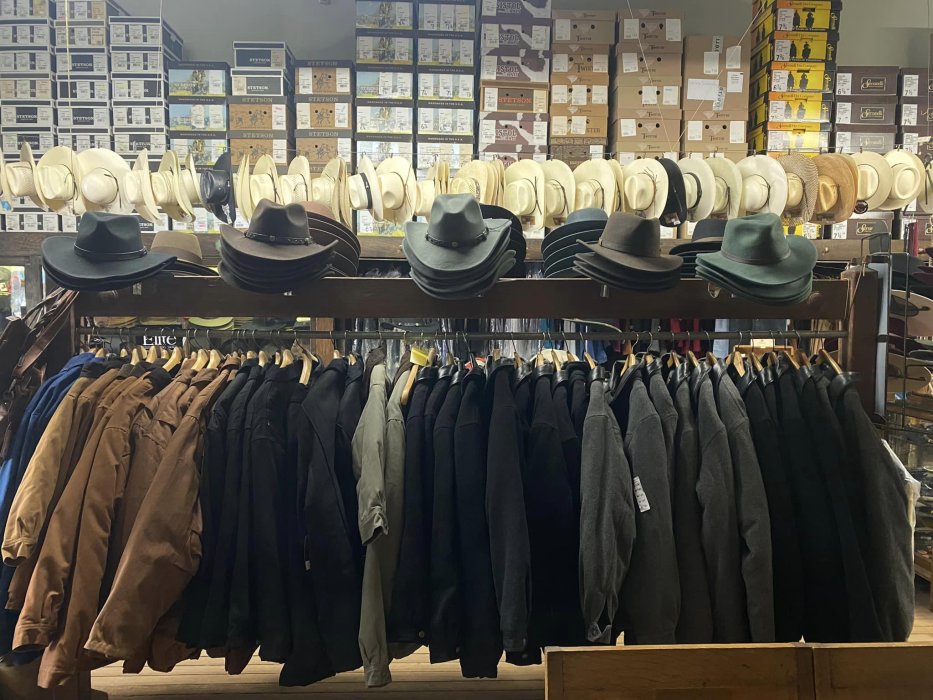 Wall of Stetson and Filson hats above racks of work jackets inside Davis Clothing Company